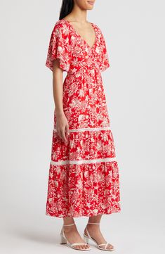 Decorative stitching highlights the tiered skirt on a flowy maxi dress covered in a mesmerizing print for visual intrigue. 51 1/2" length Slips on over head Deep V-neck Short sleeves Lined 100% rayon Hand wash, dry flat Imported Spring Red Maxi Dress With Flowy Skirt, Red Flowy Maxi Dress For Spring, Red Flowy Tiered Skirt Dress, Red Flowy Tiered Dress, Red Tiered Dress With Ruffle Hem, Red Floral Print Tiered Maxi Dress, Red Tiered Maxi Dress With Floral Print, Red Tiered Maxi Dress For Vacation, Red Tiered Maxi Dress With Ruffles