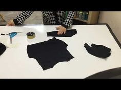 a woman is making clothes on a table with scissors and glue in front of her