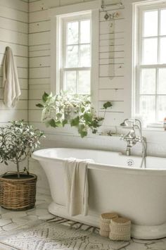 a white bath tub sitting next to two windows