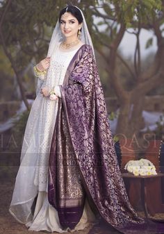 a woman in a white and purple wedding outfit