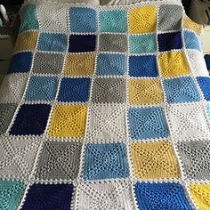 a crocheted blanket that is on top of a bed