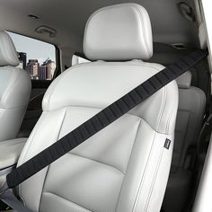 the interior of a car with white leather and black stitching on the seat belt