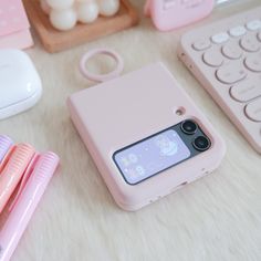 a pink phone case sitting on top of a table next to a keyboard and mouse