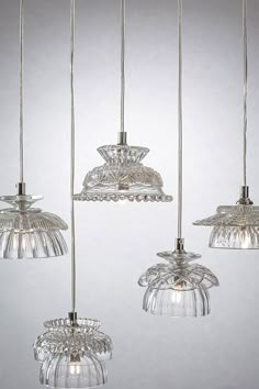 four glass lights hanging from a ceiling fixture