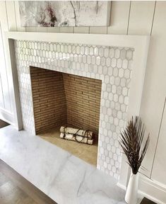 a living room with a fire place in the center and a painting on the wall