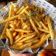 a bowl filled with french fries covered in seasoning and sprinkled with rosemary