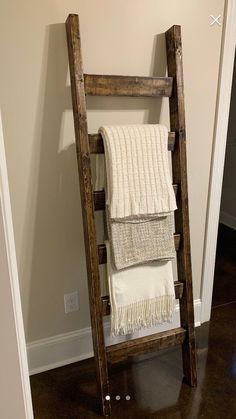 an old wooden ladder is used as a towel rack