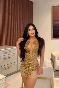 a woman in a gold dress posing for the camera