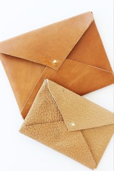 two brown envelopes sitting next to each other on a white surface, one is open and the other has an empty piece of paper in it