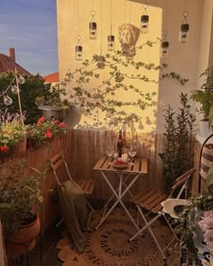 an outdoor patio with chairs, table and potted plants