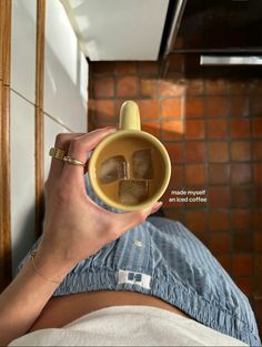 a person holding a cup with ice cubes in it