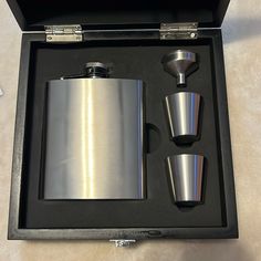 a flask and two shot glasses in a box