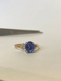 a pair of scissors sitting on top of a table next to a blue and white ring