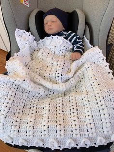 a baby is sleeping in a car seat with a blanket on it's back