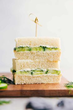 two sandwiches stacked on top of each other with cucumber slices in between them