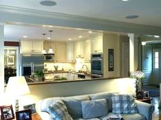 a living room filled with furniture next to a kitchen