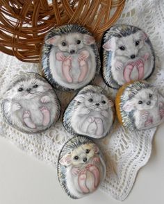 four hedgehog magnets sitting on top of a doily next to a basket