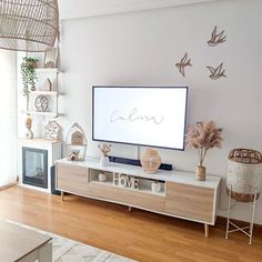 a flat screen tv sitting on top of a wooden entertainment center in a living room