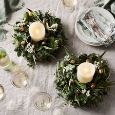 the table is set with candles and greenery