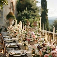 a long table is set with flowers and candles for a formal dinner or wedding reception