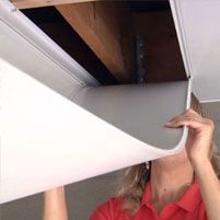 a woman in red shirt holding up the side of a white object to her face