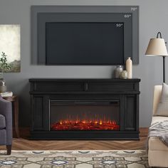 a living room with a fireplace and tv mounted on the wall next to a couch