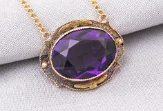 "Lovely vintage necklace features one large, oval imitation amethyst secured in scalloped bezel and a perimeter of fine, lacey filigree. The gemstone has a small chip on the back from years of love and wear. This piece has a lot of vintage look for this price! GEMSTONE: 1 Imitation Amethyst - 20.00 x 15.00mm MEASUREMENTS: 26.25 x 21.35mm ( Approximately 1\" x 1 3/4\") CHAIN: Comes with a Yellow Gold Filled 20\" long loose rope chain ERA: Circa 1910-1920 METAL: 10 Karat Yellow Gold MARKINGS: Not Antique Oval Purple Jewelry, Antique Purple Oval Jewelry, Antique Oval Purple Necklaces, Antique Purple Oval Necklaces, Purple Victorian Oval Necklace, Victorian Amethyst Oval Necklaces, Victorian Amethyst Oval Necklace, Vintage Purple Oval Pendant Necklace, Birthstone Gifts