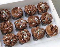 a box filled with chocolate cupcakes covered in frosting