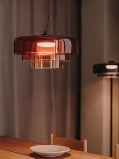 a wooden table with a plate on it and a light hanging over it in the background