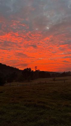 the sun is setting over an open field