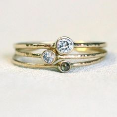 three gold rings with two diamonds on them