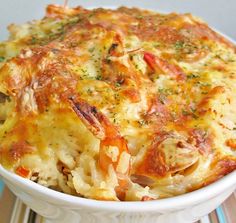 a casserole with cheese and vegetables in a white dish on a wooden table