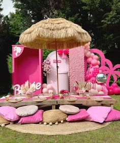 a table with pink pillows and an umbrella