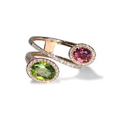 A unique bold, modern by pass design with pink tourmaline and peridot in 14k gold Peridot, symbolizes strength. It is sometimes called the “evening emerald” for its light green color Pink Tourmaline brings the energy rays of determination, commitment, and caring. Pink is the color of new love, new romance and new relationships. Diamond Information: 67 diamonds .25 cts Stone Information: 1 (6 X 4) oval pink tourmaline 1 (8 x 6) oval peridot In Stock: 1 available in 14k rose gold Color Stone Rings, Oval Stone Ring, Diamond Ring Designs Unique, Multicolor Tourmaline Ring Jewelry, Luxury Yellow Gold Tourmaline Rings, Unique Pink Tourmaline Rings, Luxury Tourmaline Cabochon Rings, Fine Jewelry Tourmaline In Pink, Multicolor Jewelry