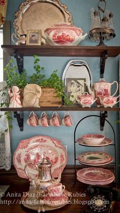 an old fashioned china cabinet with dishes and cups on it's shelves, along with other antique items