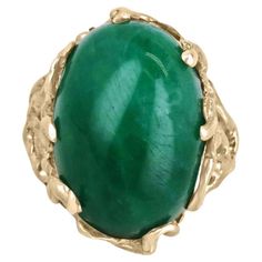 This impressive solitaire ring features a stunning centerpiece in the form of a huge 19-carat oval cabochon cut emerald from Colombia, prized for producing some of the world's most beautiful emeralds. The emerald displays a rich, dark green color that is truly captivating. The emerald is securely set in a unique 14k gold nugget style setting, with nugget prongs that add to the rugged, organic feel of the design. The result is a striking and unforgettable piece of jewelry that is sure to turn hea Luxury Emerald Ring With Oval Cabochon, Formal Emerald Cabochon Ring, Formal Oval Cabochon Emerald Ring, Modern Cabochon Emerald Ring For Formal Occasions, Modern Formal Emerald Cabochon Ring, Elegant Cabochon Emerald Ring, Elegant Emerald Ring With Cabochon Cut, Elegant Emerald Cabochon Ring, Modern Formal Emerald Ring With Oval Cabochon