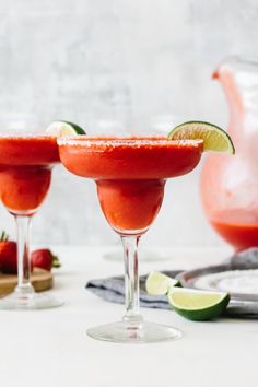 two glasses filled with watermelon margaritas and garnished with lime