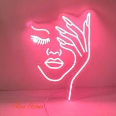 a pink neon sign with a woman's face on it and her hands in the air