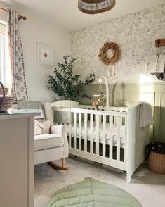 a baby's room with a crib, rocking chair, and potted plant