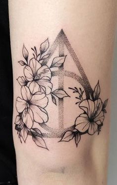 a black and white tattoo with flowers on the side of a woman's leg