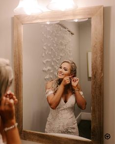 a woman standing in front of a mirror brushing her teeth