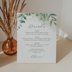 a menu card sitting on top of a table next to a vase filled with flowers