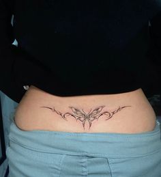 a woman's stomach with a butterfly tattoo on her lower back and side ribs