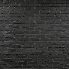 an old brick wall is painted black