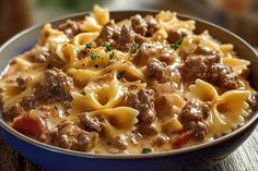 a blue bowl filled with pasta and meat