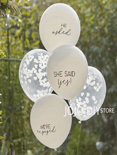 white balloons that say she said yes, we're engaged and he spokee