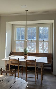 a dining room table and chairs in front of a window with snow on the ground