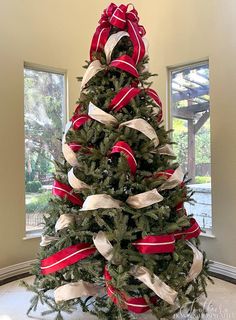 a decorated christmas tree with red and white ribbons