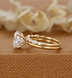 two gold wedding rings sitting on top of each other next to a white flower bouquet