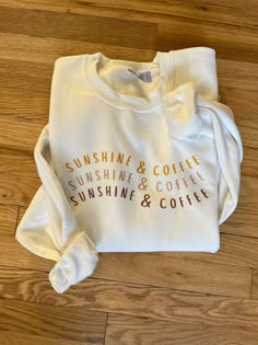 "This \"Sunshine & Coffee\" sweatshirt will be one of your favorites. Wear it on a cold winter day while you dream of summer or a cool summer evening by the fire.  It is a white Gildan 18000 sweatshirt with a custom heat transfer vinyl transferred on. This item is handmade therefore it is delicate. Treat this item with love so you can love it longer. Please wash on delicate inside-out and air dry or dry on low inside-out." Cricut Crew Neck Sweatshirt, Cricut Sweatshirt Ideas Women, Cricut Sweatshirt Ideas, Sweatshirt And Shirt Outfit, Sunshine And Coffee, Shirt Outfit Ideas, Coffee Sweatshirt, Cute Shirt Designs, Sweatshirt Cute